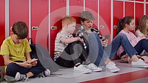 Tracking video of group of children using smartphone at school.