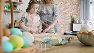 Tracking video of three generations of women preparing Easter cake.