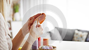 Tracking video of woman sews carrots at home.