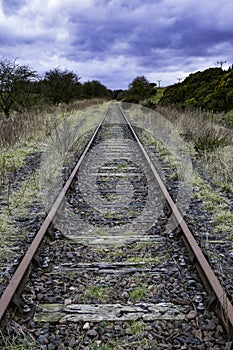 Tracks of abandoned railway line with dramatic sky