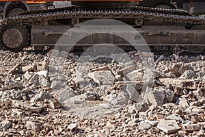 Tracks of excavator over loads of rubble debris