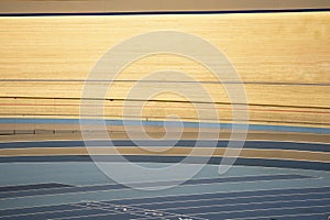 Tracks of an indoor track cycling velodrome with wooden course race-track and a blue floor photo