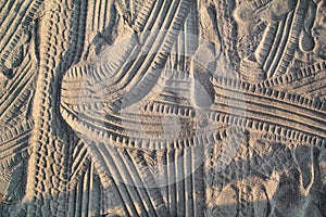 Tracks in sand. Part of prints and tracks of tire, foot, feet, sun sea slippers in beach sand.