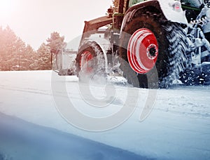 Tracktor cleaning on winter road covered with snow