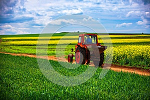 Tractor in a agricultural fields and dramatic clouds