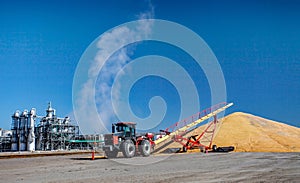 Tractor and Auger Unloading Corn at Ethanol Plant in the Midwest
