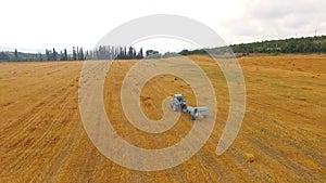 Tractor Baler Making Hay Bales In Stubble Field