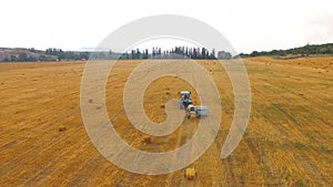 Tractor Baler Making Straw Bales In Stubble Field