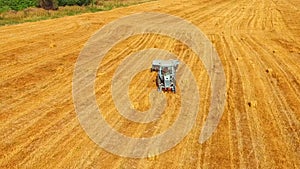 Tractor Baler Moving Across Yellow Stubble Field