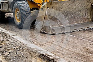 Tractor with bucket performs road works