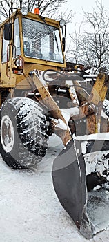 Tractor bucket for snow cleaning. Snow removal on the roads. Snowplow in the winter in the city