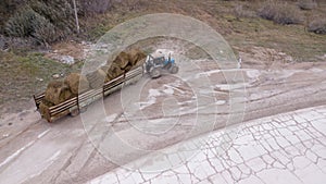 The tractor carries the bales of straw top view