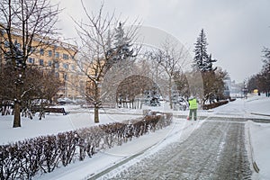 Tractor cleaning the road from the snow. Excavator cleans the st