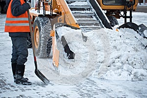 Tractor cleaning the road from the snow. Excavator cleans the streets of large amounts of snow