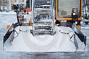 Tractor cleaning the road from the snow. Excavator cleans the streets of large amounts of snow in city.