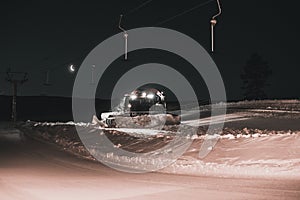 Tractor cleaning snow on the ski slopes in the Alps