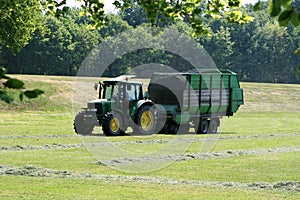 Tractor is collecting grass