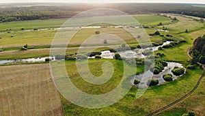 Tractor collecting hay bales. Aerial footage of farmer & haystacks