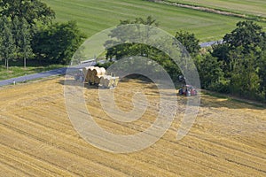 tractor collecting straw bales harvest concept