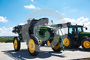 Tractor, combine at a field in sunlight. Confident, bright colors