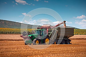 Tractor and Combine harvester machine working in a wheat agricultural field, harvest time