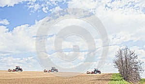 Tractor compresses the soil after planting with rollers.