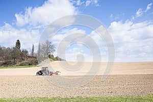 Tractor compresses the soil after planting with rollers.