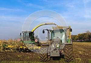 Tractor and corn harvester on the corn field