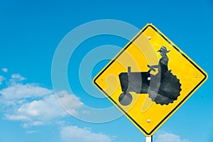 Tractor crossing sign with a sky blue background