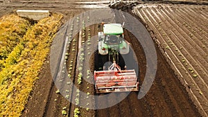 Tractor cultivates the land in the field.