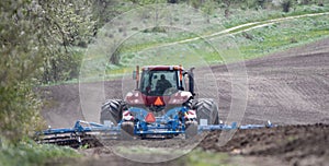 Tractor cultivating field with a cultivator selective focus