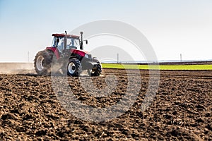 Tractor cultivating field at spring