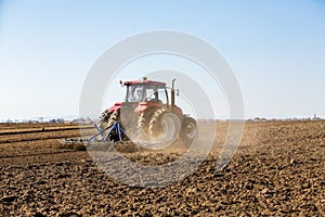 Tractor cultivating field at spring