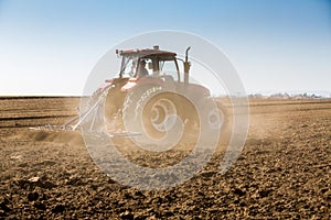 Tractor cultivating field at spring