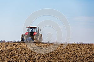 Tractor cultivating field at spring