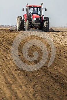 Tractor cultivating field at spring