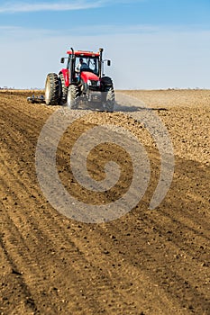 Tractor cultivating field at spring