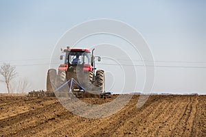 Tractor cultivating field at spring