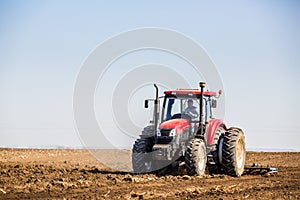 Tractor cultivating field at spring