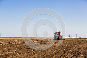 Tractor cultivating field at spring