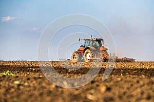 Tractor cultivating field at spring