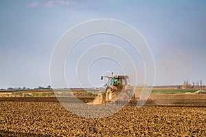 Tractor cultivating field at spring