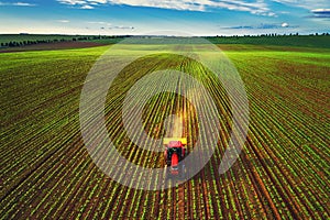 Tractor cultivating field at spring, aerial view