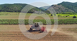 Tractor cultivating the ground in a agricultural field. Agronomy, agriculture and farming concept