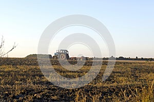 Tractor cultivating wheat stubble field with crop residue