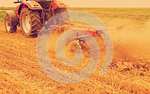 Tractor cultivating wheat stubble field photo