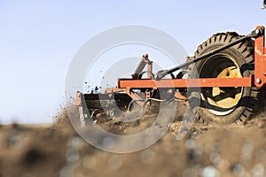Tractor with cultivator handles field before planting
