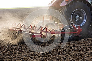 Tractor with cultivator handles field before planting