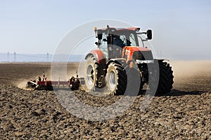 Tractor with cultivator handles field before planting. Preparing land for sowing at spring