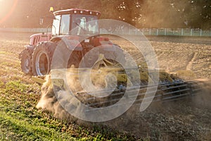 Tractor cultivator plows the land, prepares for crops. dust on field